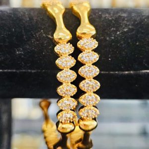 White stone bangle with floral gold plated designs